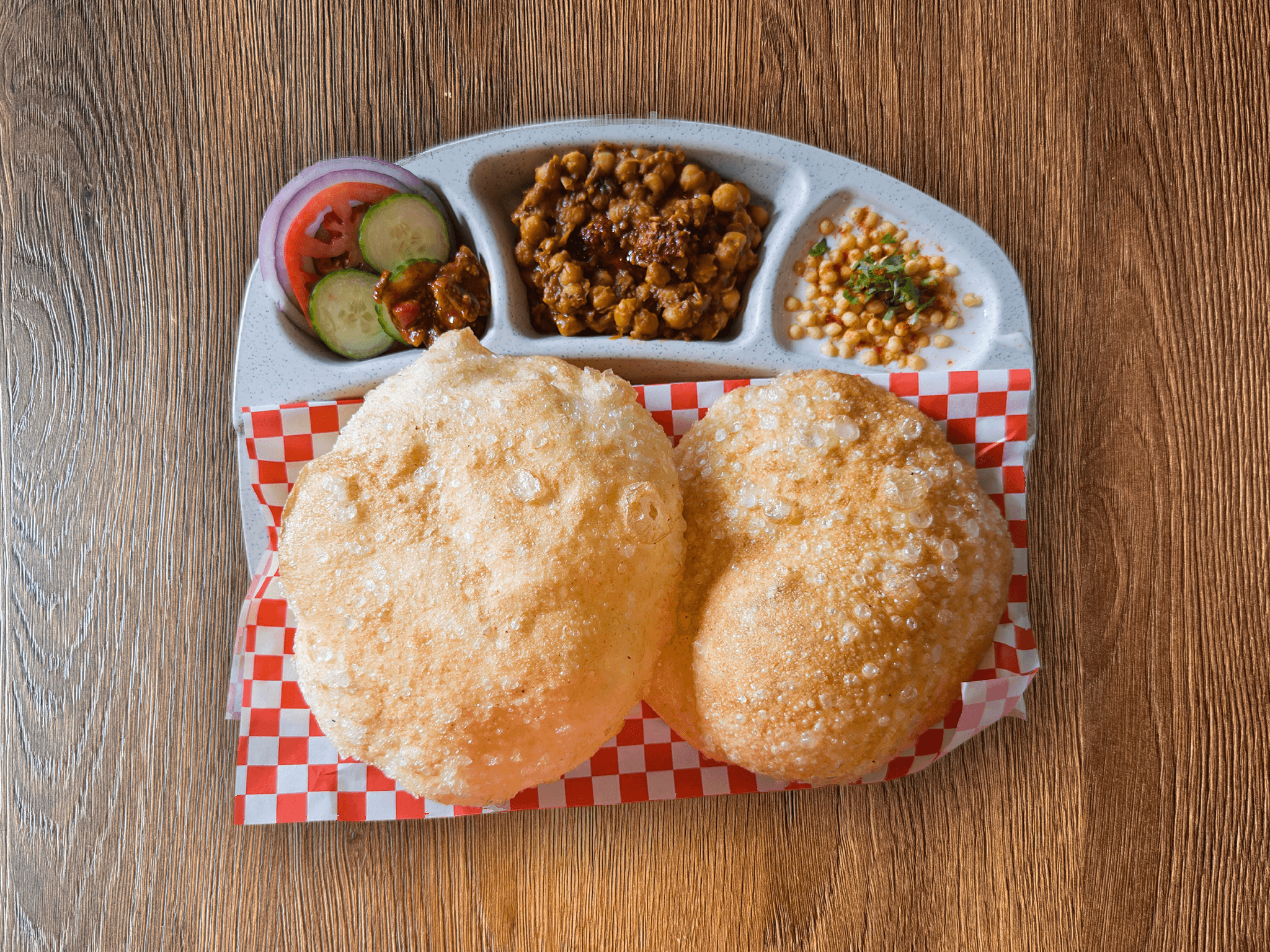Traditional Chana Bhatura (Chole Bhature) - golden puffy fried bread served alongside flavorful spiced chickpea curry, authentic North Indian street food dish